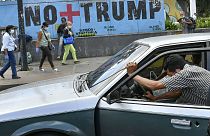 یک شهروند ساکن کاراکاس خودروی خود را که بنزینش تمام شده، هل می‌دهد