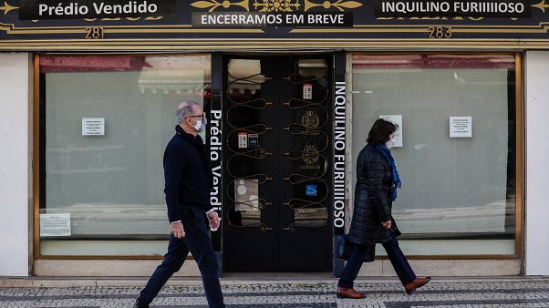 Traseuntes passam por uma loja fechada na zona da baixa pombalina de Lisboa Traseuntes passam por uma loja fechada na zona da baixa pombalina de Lisboa