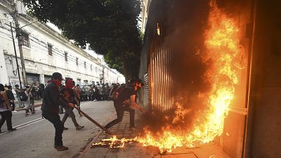 Demonstrators set on fire part of the Congress building during a protest demanding the resignation of Guatemalan President Alejandro Giammattei.