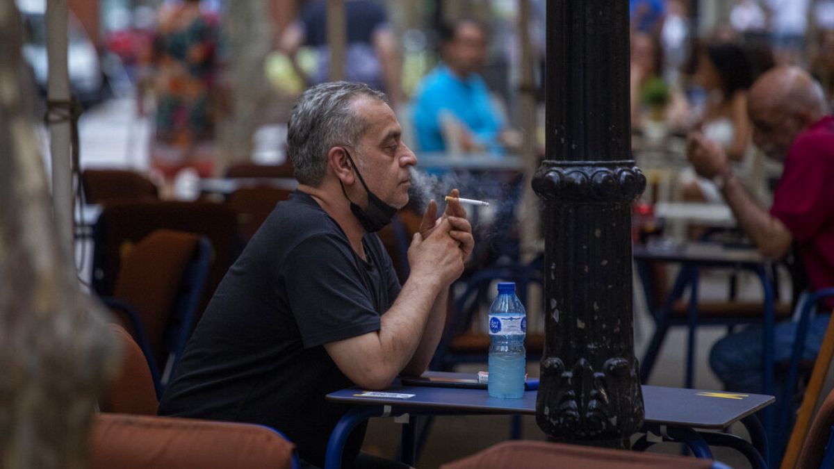 A man smokes on a terrace bar in Barcelona