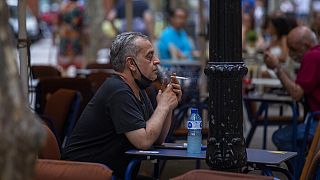 A man smokes on a terrace bar in Barcelona