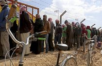 Syrian refugees line up to register their names at an employment office, at the Azraq Refugee Camp in Jordan.