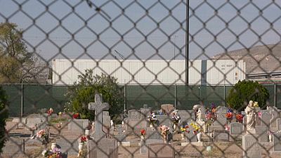 Imagen del cementerio de El Paso con varios camiones frigoríficos al fondo conteniendo cadáveres de víctimas de la COVID-19