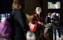 A woman waits in line for a train at the 30th Street Station ahead of the Thanksgiving holiday, Friday, Nov. 20, 2020, in Philadelphia.