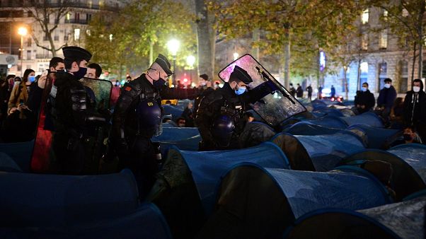 Police forcefully dismantle a refugee camp in central Paris.