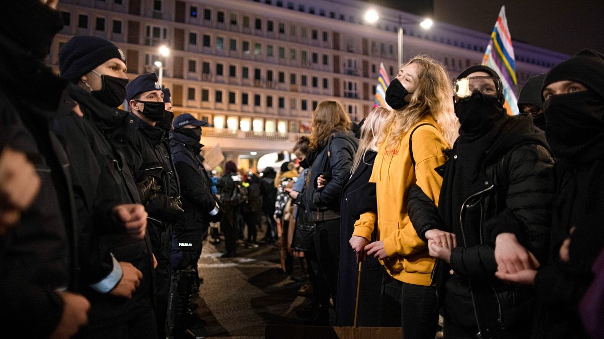Protesters face a line of police officers during a demonstration against a top court ruling restricting abortions in Warsaw, Poland, Wednesday, Nov. 18, 2020.