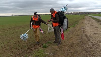 Frédéric and Edmund walking in the open country and collecting rubbish