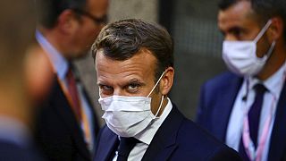 French President Emmanuel Macron, center, leaves the European Council building in the early morning during an EU summit in Brussels, Monday, July 20, 2020