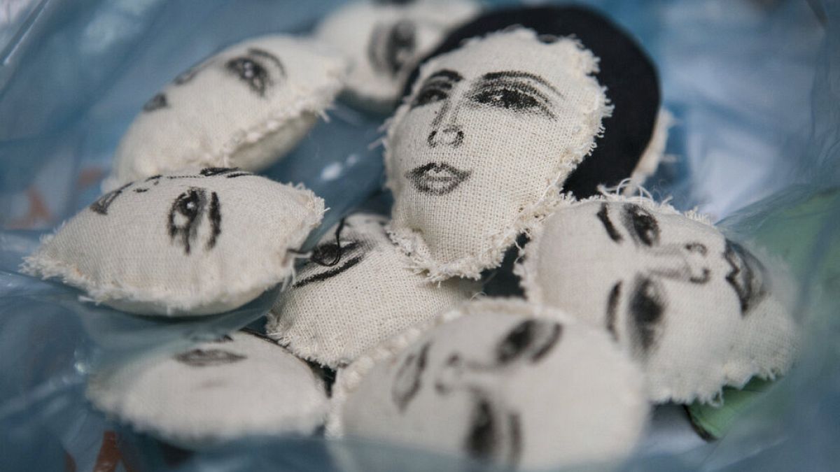 The hand-painted faces of women decorate small pillows before being made into key rings by Erika Martinez