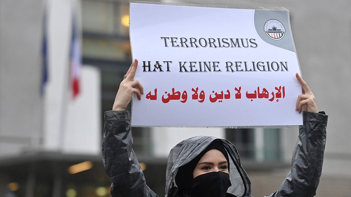 متظاهر يرفع لافتة كتب عليها "الإرهاب لا دين له" خلال مسيرة لجمعيات فلسطينية وعربية أمام السفارة الفرنسية في برلين، 30 أكتوبر 2020