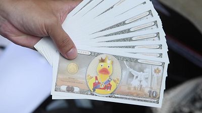 نقود رمزية تحمل صورة بطة بلباس ملكي تداولها المتظاهرون في تايلاند