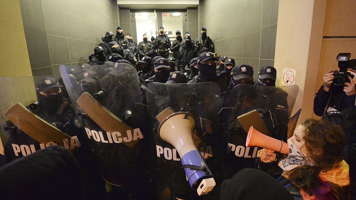 People block access to a police station where a few demonstrators are being detained after a pro-choice demonstration in Warsaw in Warsaw, Poland, Monday Nov. 23, 2020.