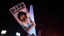 مشجع لكرة القدم يرفع علما يحمل صورة مارادونا في العاصمة الأرجنتينية بيونس آيرس. 2020/11/25