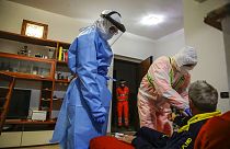 Medical staffer Ruggero Gariboldi, right, measures oxygen level in the blood of a suspected Covid patient