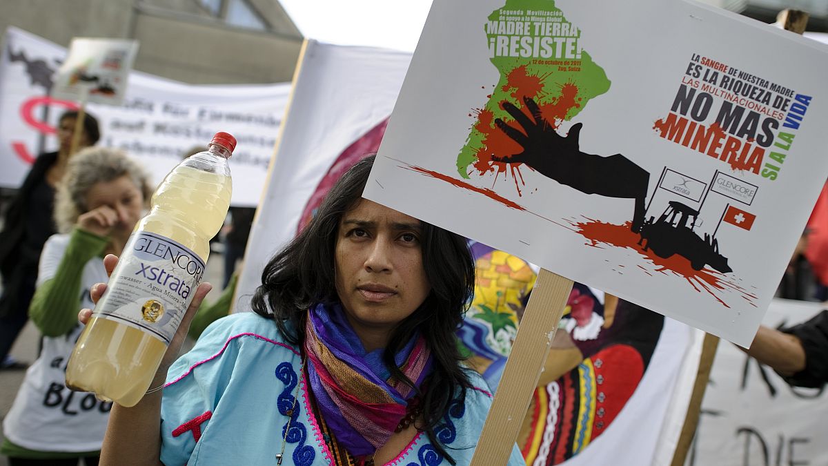 Kolombiyalı bir kadın, İsviçreli Glencore'un maden işletmesinden dolayı kirlenen suyunu gösteriyor