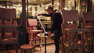 A waiter checks the final revenue as he closes a bar terrace in Paris, Saturday, Oct. 17