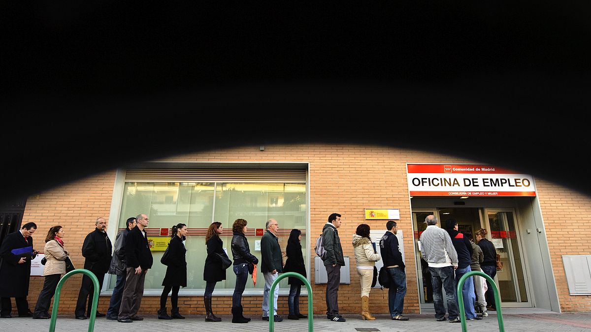 People line up to enter a government job center in Madrid,
