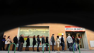 People line up to enter a government job center in Madrid,