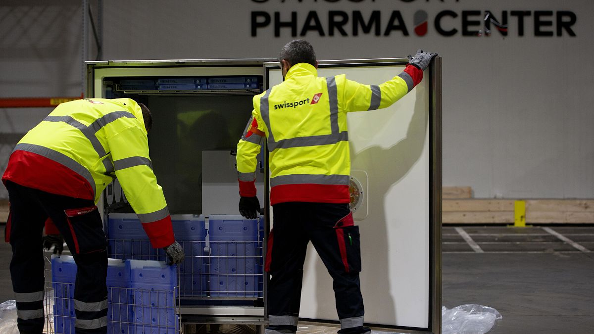 Cargo workers demonstrate the cold chain process for the handling of medicines and vaccines at Swissport Pharma Center in Machelen, Belgium, Nov. 25, 2020. 