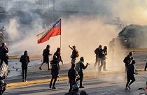 Protester holding Chilean flag march clashes with police