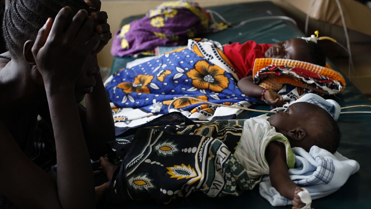 Kenya'nın batısında sıtma rahatsızlığına yakalanan çocuğuna bakan bir kadın (arşiv)