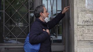 Priest Don Giorgio Pisano talks to a parishioner through the Intercom. 