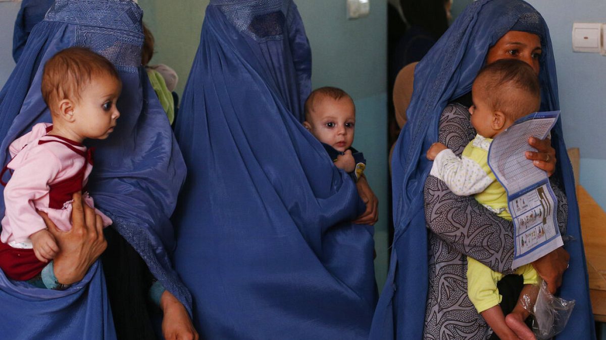Mothers hold their babies suffering from malnutrition as they wait at a UNICEF clinic in Jabal Saraj, north of Kabul, Afghanistan