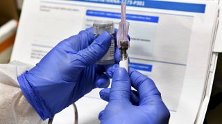 FILE - In this July 27, 2020, file photo, nurse Kathe Olmstead prepares a shot that is part of a possible COVID-19 vaccine.