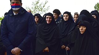  In this May 12, 2020. file photo, Serbian ambassador in Montenegro Vladimir Bozovic, left, and believers wait in front of the Christian Orthodox monastery of Ostrog.
