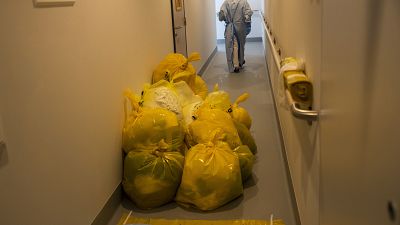 A medical worker passes by contaminated waste products in a hallway outside the intensive care ward for Covid-19 patients at the MontLegia CHC hospital in Liege.