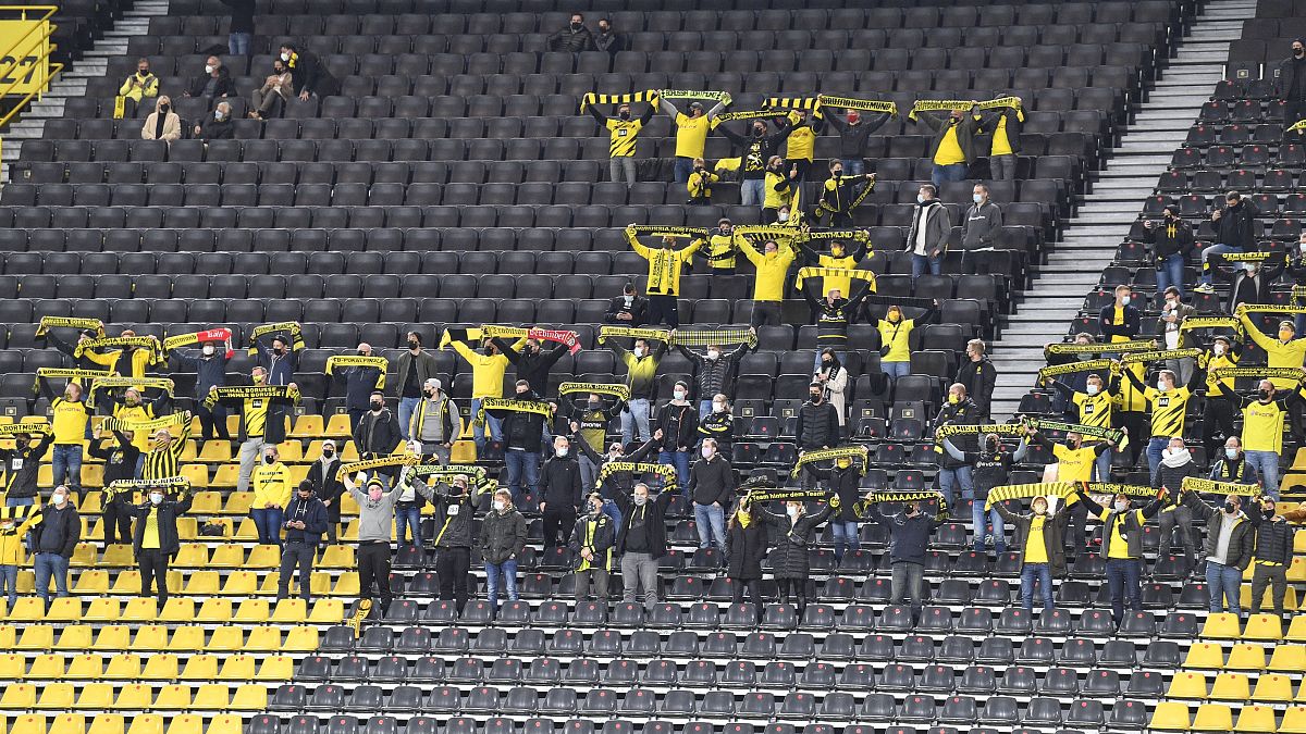 Anhänger von Borussia Dortmund umgeben von leeren Sitzen. 