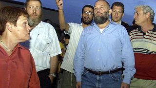 إيفي إيتام بقميص أزرق عندما كان وزيرا للإسكان والبناء يتوسط عددا من المستوطنين اليهود في مستوطنة شمال القدس. 2002/10/13