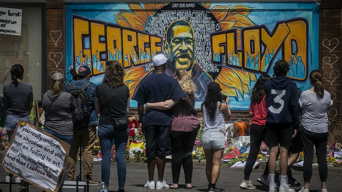  visitors make silent visits to organic memorial featuring a mural of George Floyd, near the spot where he died while in police custody, in Minneapolis.