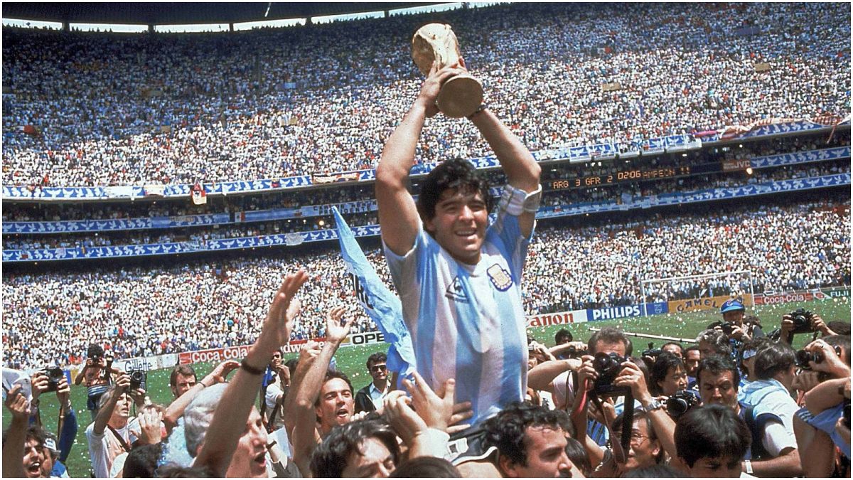 مارادونا يحمل كأس العالم التي فاز بها منتخبه الأرجنتين عام 1986