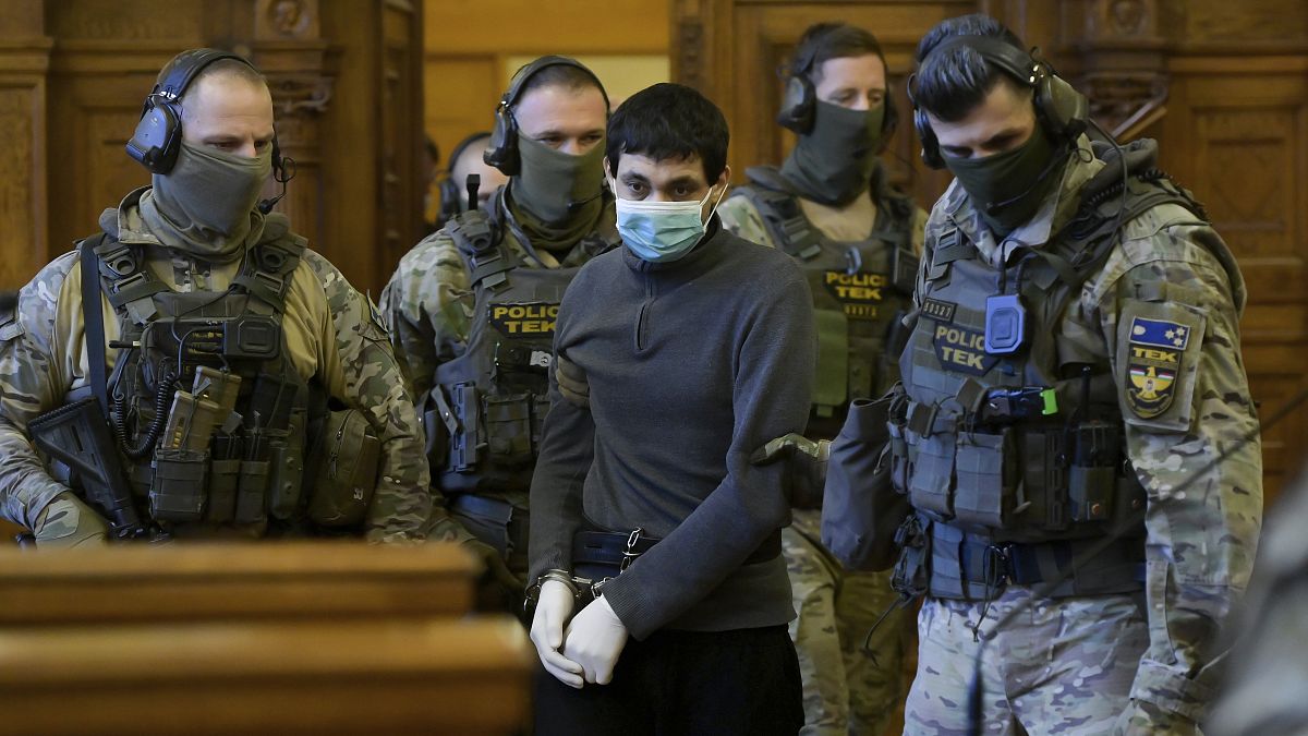 Hassan F., a Syrian man accused of mass executions, terrorist acts and crimes against humanity is escorted by Hungarian police special unit officers as he arrives in the court