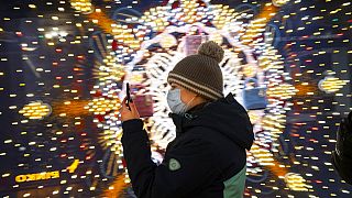 A visitor wearing a face mask to help curb the spread of the coronavirus looks at her smartphone as she walks in the GUM State Department store in Moscow