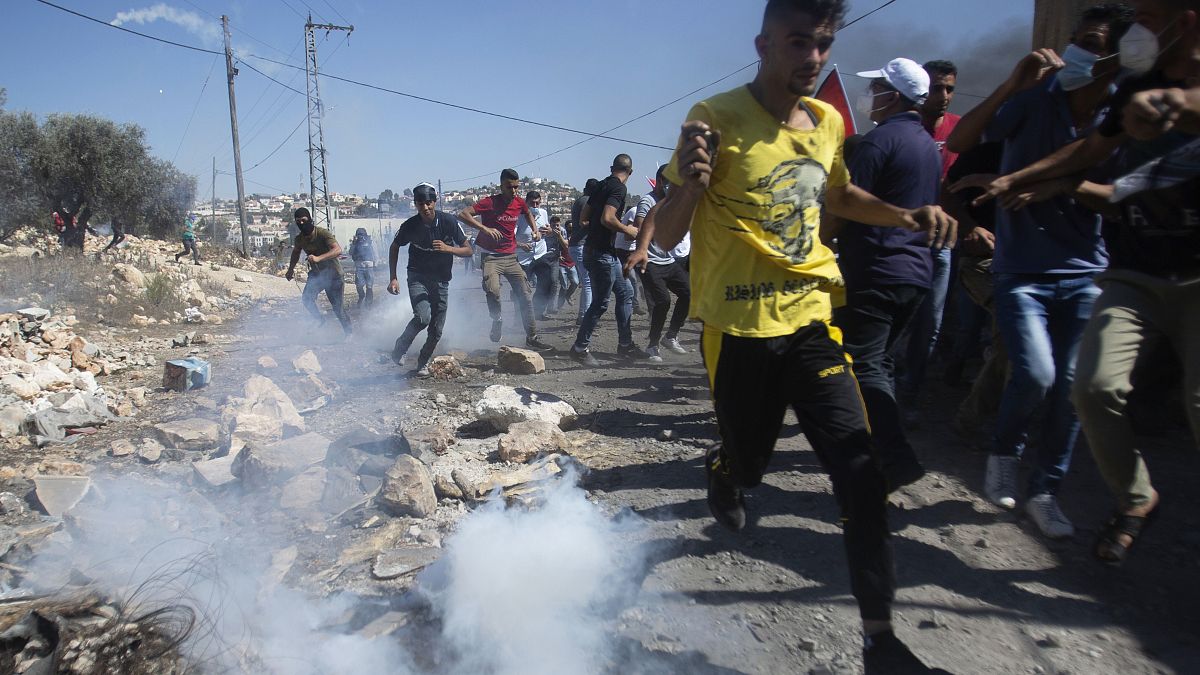  فلسطينيون يفرون من الغاز المسيل للدموع خلال تظاهرة في الضفة الغربية المحتلة
