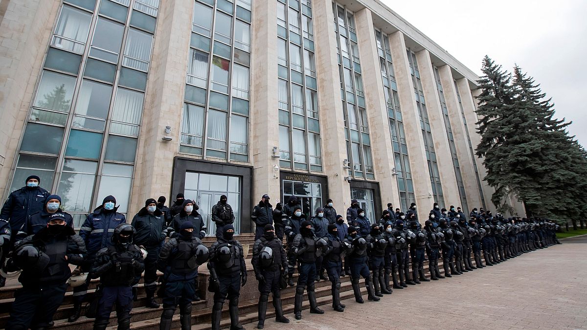 Riot police forces stand guard in front of the government building