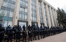 Riot police forces stand guard in front of the government building