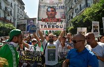 متظاهر جزائري يرفع لافتة "حرروا كريم طابو" أثناء مظاهرة شعبية أيلول/2019