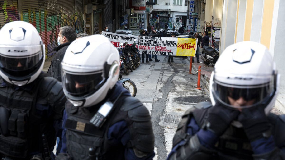 Policemen block a group of protesters as part of a general ban on gatherings, during the anniversary of the killing of a teenager 12 years ago, in Athens