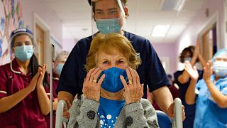 Margaret Keenan, 90, is applauded by staff after becoming the first patient in the UK to receive the Pfizer-BioNTech vaccine, at University Hospital, Coventry, Dec. 8, 2020.