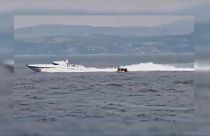 Boot der türkischen Küstenwache und Boot mit Migranten.
