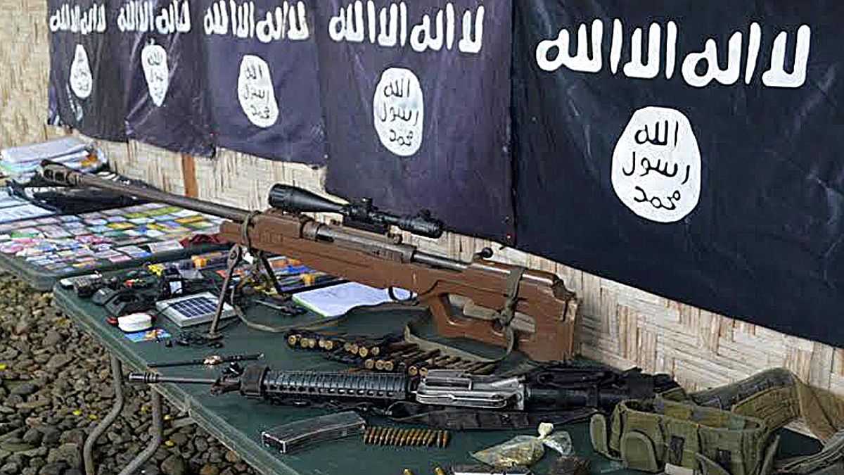 أسلحة وأعلام داعش التي تم انتشالها من أفراد عصابة إجرامية انضمت لداعش في بلدة باليمبانغ، الفليبين. 