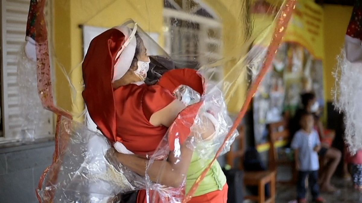 تماس عاطفی با حفظ فاصله‌ اجتماعی؛ زن برزیلی آغوشش را با پرده پلاستیکی باز می‌کند