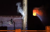 ARCHIVE - Firefighters work to extinguish a fire at a building in Badalona, Barcelona.