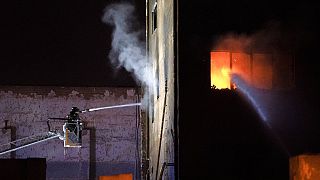 ARCHIVE - Firefighters work to extinguish a fire at a building in Badalona, Barcelona.