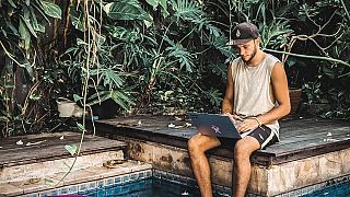 A young freelancer works by the pool at Dojo Bali Co-working camp