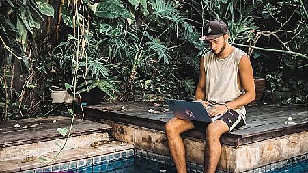 A young freelancer works by the pool at Dojo Bali Co-working camp