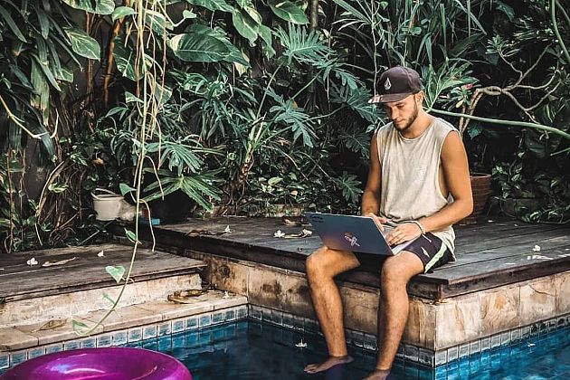 A young freelancer works by the pool at Dojo Bali Co-working camp